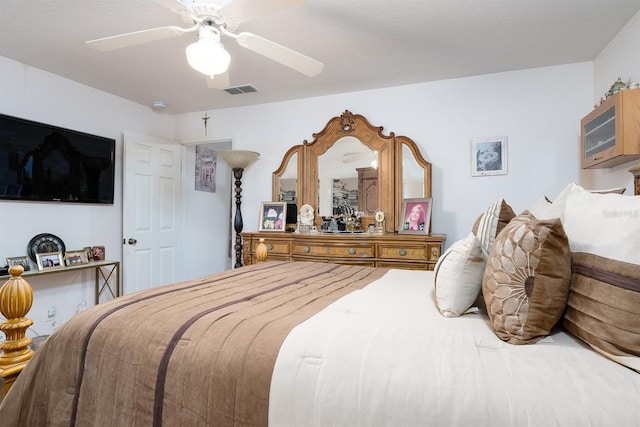 bedroom with ceiling fan and a textured ceiling