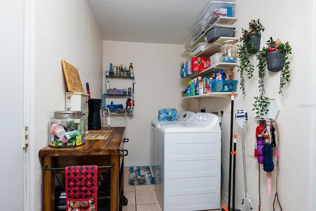 laundry room featuring independent washer and dryer, a textured ceiling, and light tile patterned floors