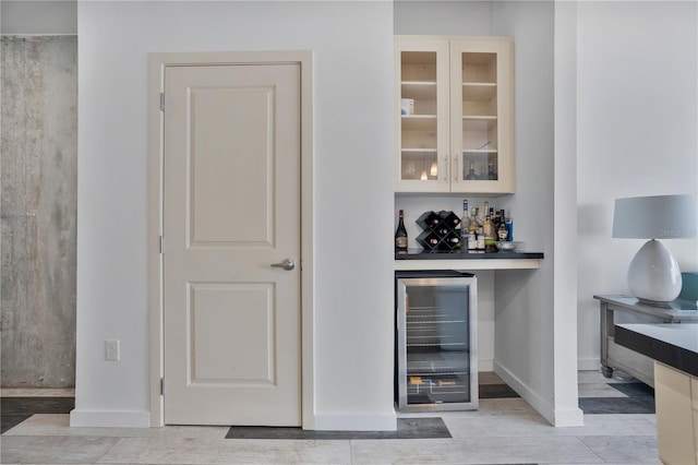 bar featuring light hardwood / wood-style flooring and beverage cooler