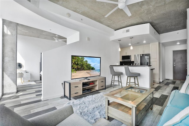 living room featuring ceiling fan and light hardwood / wood-style flooring