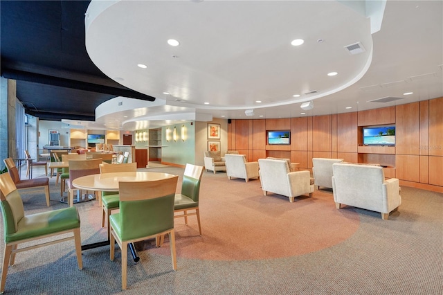 carpeted dining space with a tray ceiling