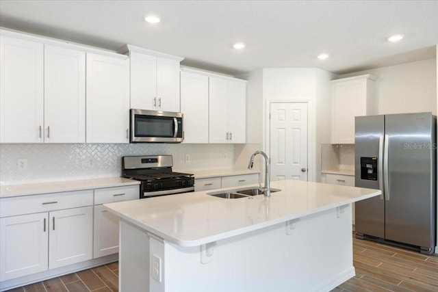 kitchen with a center island with sink, sink, white cabinetry, and stainless steel appliances