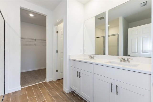 bathroom with vanity and a shower with shower door