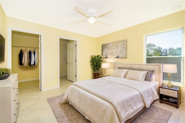 bedroom with a spacious closet, a closet, and ceiling fan