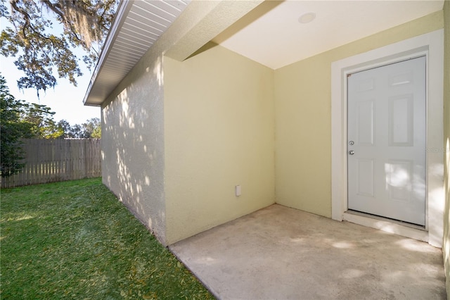 property entrance with a yard and a patio area