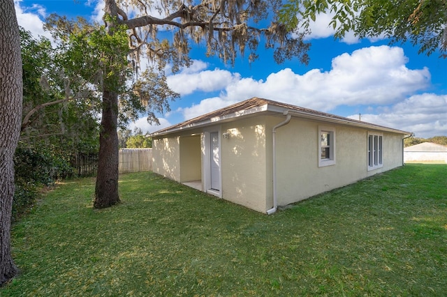 view of side of home with a yard