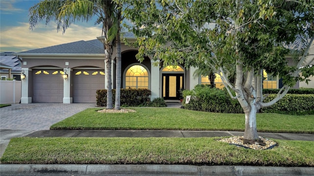 view of front facade featuring a garage and a lawn