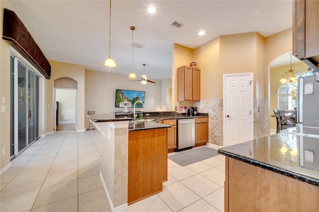 kitchen featuring dishwasher, hanging light fixtures, light tile patterned floors, and dark stone countertops