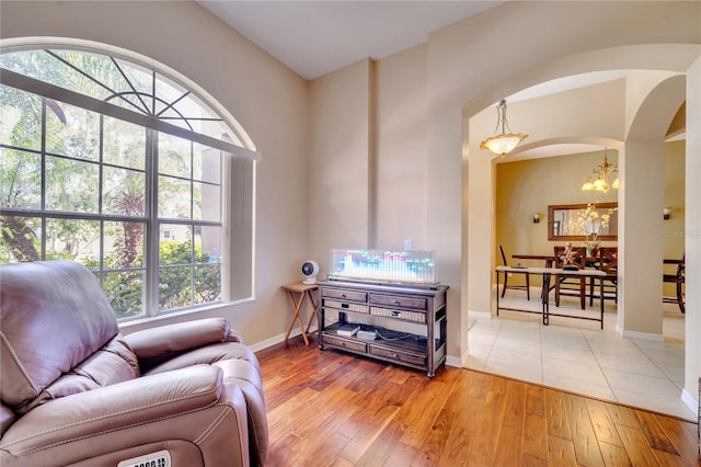 living area featuring light hardwood / wood-style flooring, a notable chandelier, and plenty of natural light