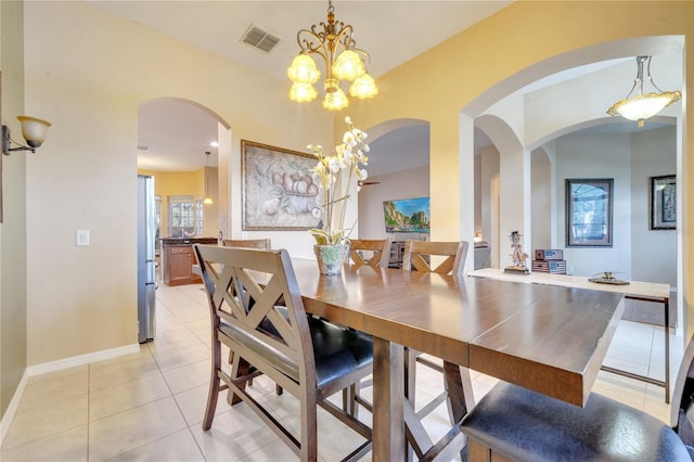 tiled dining space featuring an inviting chandelier