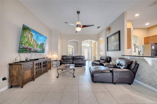 tiled living room with ceiling fan and french doors