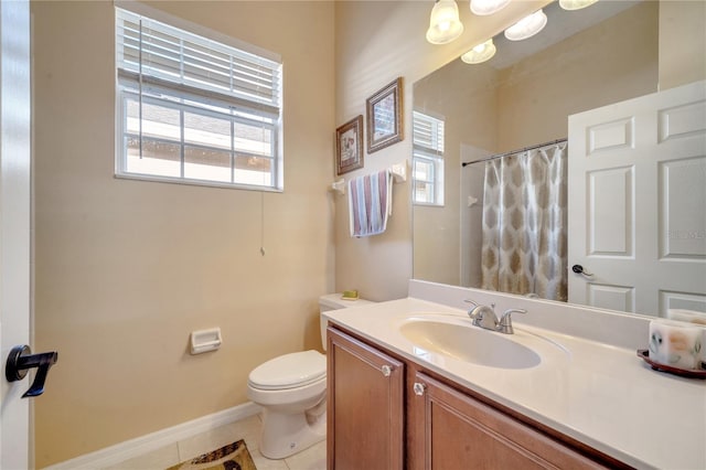 bathroom with toilet, vanity, tile patterned floors, and a healthy amount of sunlight