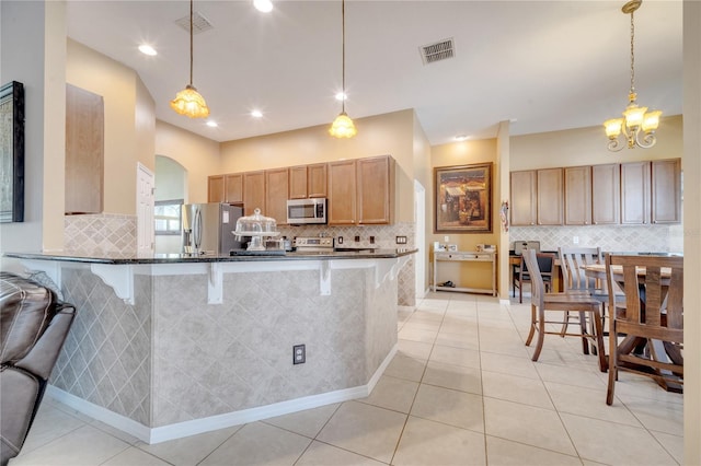 kitchen featuring pendant lighting, stainless steel appliances, and a breakfast bar area