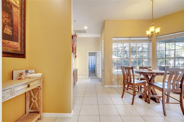 dining area with a wealth of natural light, an inviting chandelier, and light tile patterned floors