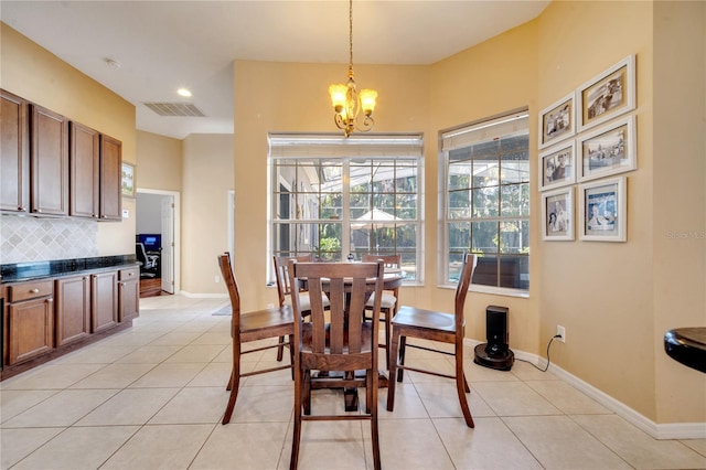 dining area with a chandelier and light tile patterned floors