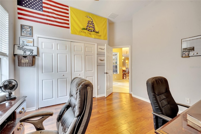 office space with a high ceiling and hardwood / wood-style floors