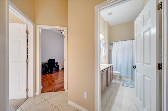 bathroom with toilet, vanity, tile patterned floors, and a shower with shower curtain