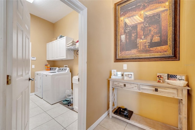 laundry area featuring cabinets, separate washer and dryer, and light tile patterned floors