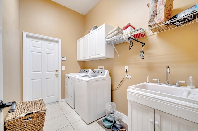 laundry area with washing machine and dryer, cabinets, sink, and light tile patterned floors