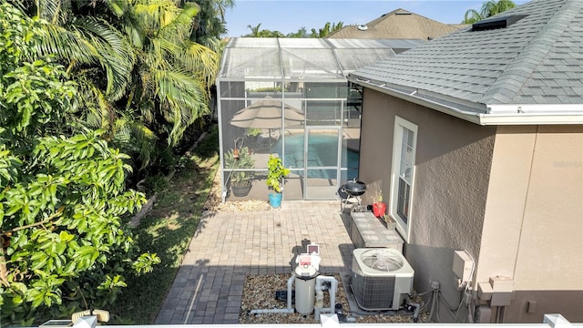 view of property exterior with glass enclosure, a patio area, and cooling unit