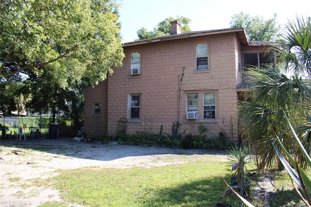 view of home's exterior with cooling unit and a yard