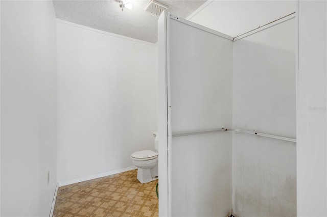 bathroom featuring a textured ceiling and toilet