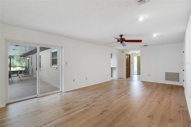 unfurnished living room featuring ceiling fan, a textured ceiling, and light hardwood / wood-style flooring