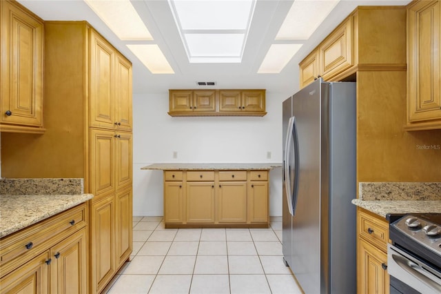 kitchen with light stone countertops, appliances with stainless steel finishes, and light tile patterned floors