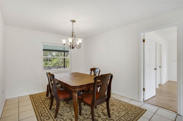 tiled dining room with a chandelier