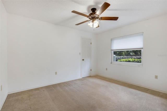 carpeted empty room with ceiling fan and a textured ceiling