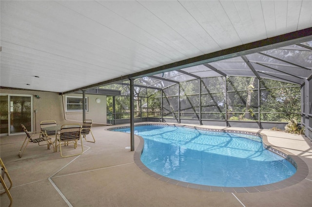 view of pool featuring glass enclosure and a patio