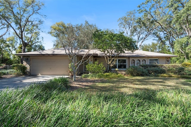 single story home with a garage and a front lawn