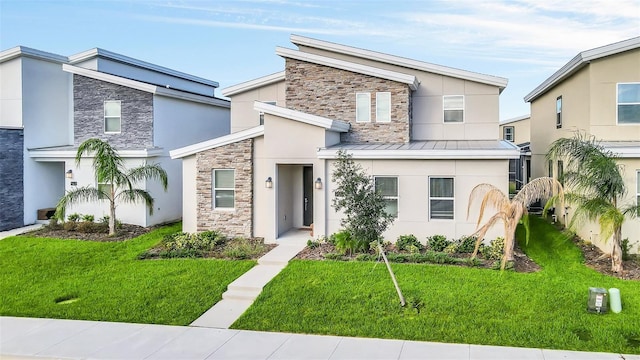 730 Drop Shot Dr, Davenport, FL 33896 - contemporary home with stone siding, stucco siding, a front yard, and a standing seam roof
