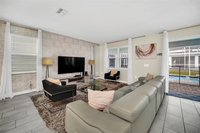 730 Drop Shot Dr, Davenport, FL 33896 - living room featuring an accent wall, wallpapered walls, and baseboards