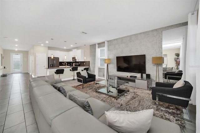 730 Drop Shot Dr, Davenport, FL 33896 - living room with light tile patterned flooring, baseboards, recessed lighting, wallpapered walls, and an accent wall