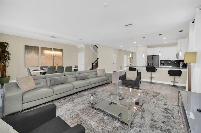 tiled living room featuring a notable chandelier