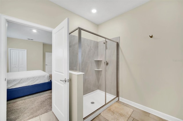 bathroom featuring a shower with shower door and tile patterned flooring