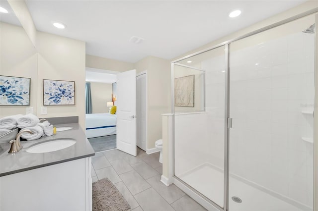 bathroom with vanity, toilet, tile patterned floors, and a shower with shower door