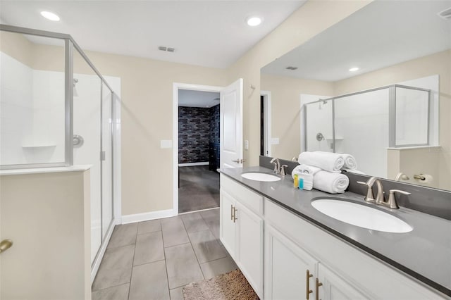 bathroom featuring vanity, a shower with shower door, and tile patterned flooring