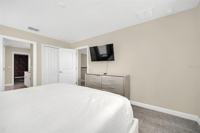 carpeted bedroom with a closet and ensuite bath