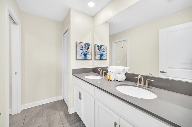 730 Drop Shot Dr, Davenport, FL 33896 - bathroom with double vanity, baseboards, and tile patterned flooring