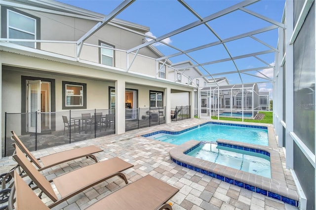 view of pool with an in ground hot tub, a patio, and a lanai