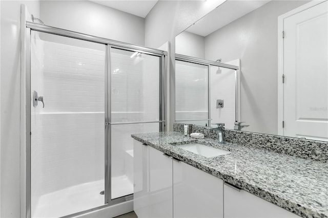 bathroom with a shower with door and vanity