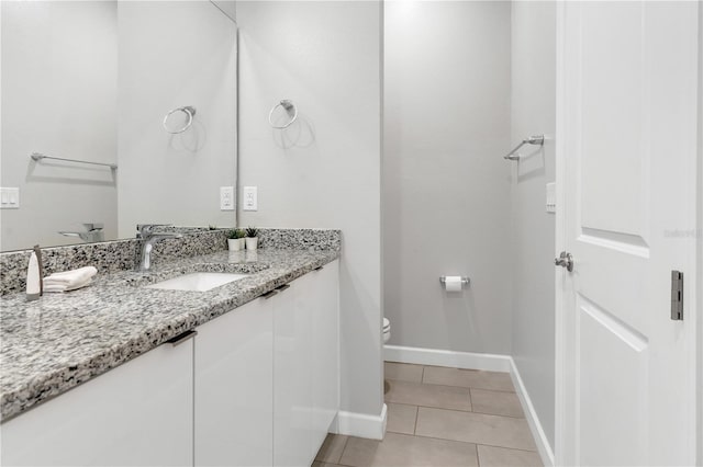 bathroom with tile patterned flooring, vanity, and toilet