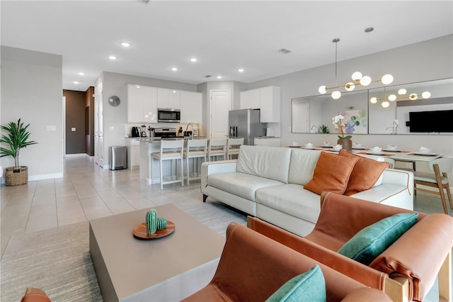 living room with a notable chandelier and light tile patterned floors