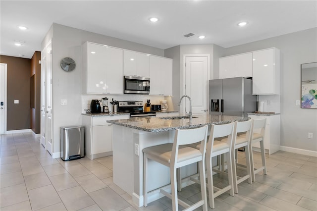 kitchen featuring a center island with sink, sink, white cabinetry, and stainless steel appliances