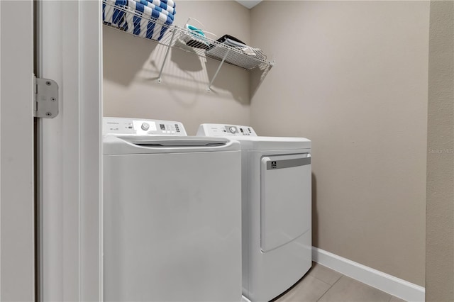 washroom featuring washing machine and dryer and light tile patterned floors