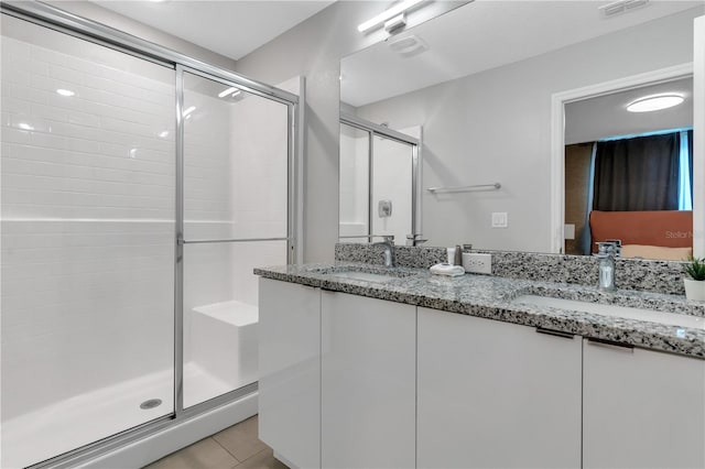 bathroom featuring tile patterned flooring, vanity, and a shower with shower door