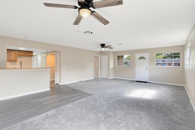 unfurnished living room with wood-type flooring and ceiling fan