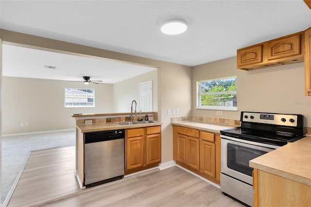 kitchen with ceiling fan, stainless steel appliances, sink, and a wealth of natural light